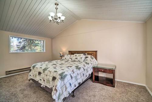 a bedroom with a bed and a window and a chandelier at Peaceful Mountain-View Home - Walk to Kenai Lake! in Cooper Landing