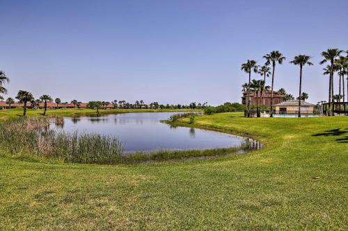 a pond in the middle of a field with palm trees at Condo on Golf Course - 10 Mi to South Padre Island in Laguna Vista