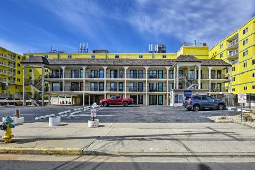 a large yellow building with cars parked in a parking lot at Coastal Condo with Pool, 1 Block to Wildwood Beach! in Wildwood