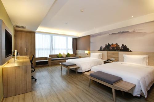 a hotel room with two beds and a television at Atour Hotel (Xi'an Gaoxin Dazhai Road) in Xi'an