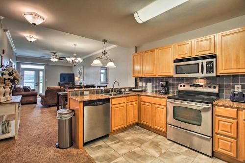 a kitchen with wooden cabinets and stainless steel appliances at Sevierville Resort Retreat about 2 Mi to Pigeon Forge! in Pigeon Forge