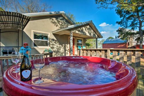 a hot tub with a bottle of wine and two glasses at Broken Bow Cottage with Deck, Hot Tub and Fire Pit! in Broken Bow