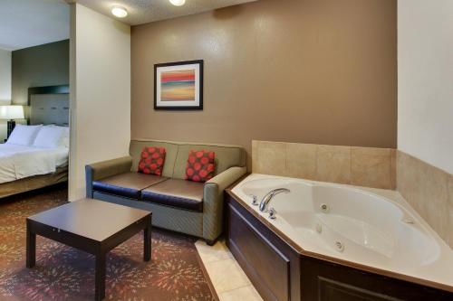a bathroom with a tub and a couch and a bed at Holiday Inn Express Hotel & Suites Lancaster-Lititz by IHG in Lititz