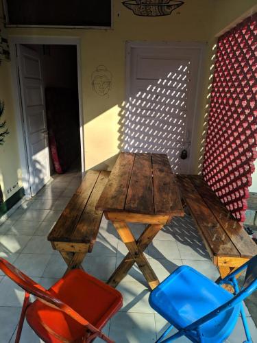 a wooden table and two chairs in a room at Gibbon Backpackers Hostel in Guwahati