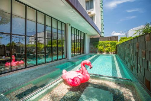 two pink flamingos in a swimming pool in a building at Grand Livio Kuta Hotel in Legian
