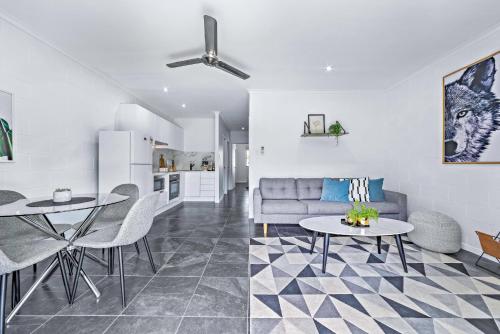 a living room with a couch and a table at Modern Beach Front Apartment in Airlie Beach