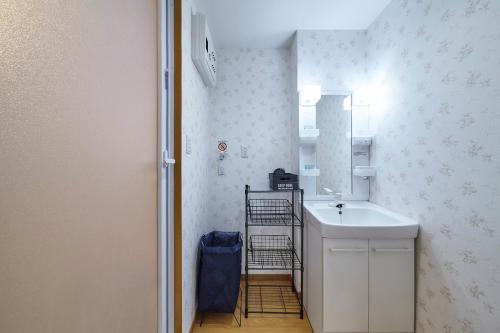 a bathroom with a sink and a mirror at おやど紀伊国屋本石灰町 in Nagasaki