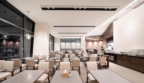 a restaurant with tables and chairs in a room at Nine Tree by Parnas Seoul Dongdaemun in Seoul