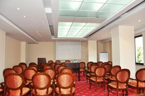 a room with rows of chairs and a podium at Hotel Victoria in Piteşti