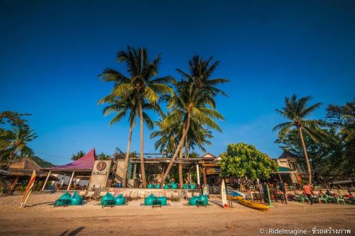 a beach with chairs and palm trees and a resort at Wind Beach Resort in Koh Tao