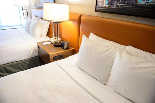 a hotel room with two beds and a lamp on a night stand at Crowne Plaza Dulles Airport by IHG in Herndon