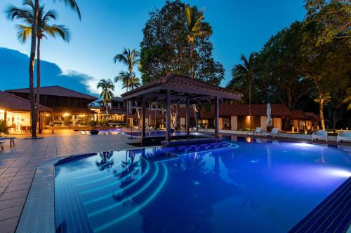 a swimming pool at night with a gazebo at Adena Beach Resort in Kuantan