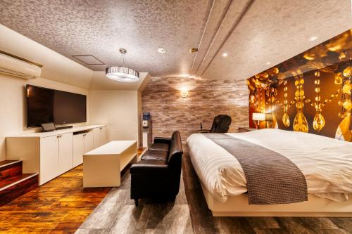 a hotel room with a bed and a flat screen tv at HOTEL LUNA MODERN Sakuranomiya (Adult Only) in Osaka