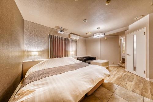 a bedroom with a large bed and a desk at HOTEL LUNA MODERN Sakuranomiya (Adult Only) in Osaka