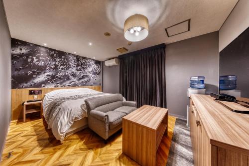 a bedroom with a bed and a desk and a television at HOTEL LUNA MODERN Sakuranomiya (Adult Only) in Osaka