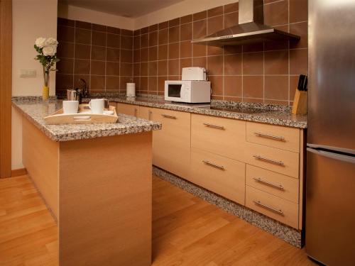 a kitchen with a sink and a refrigerator at Apartamentos Boabdil in Sierra Nevada