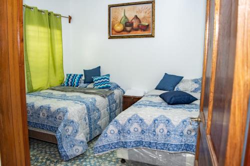 a bedroom with two beds and a picture on the wall at Mixtepek in Juayúa