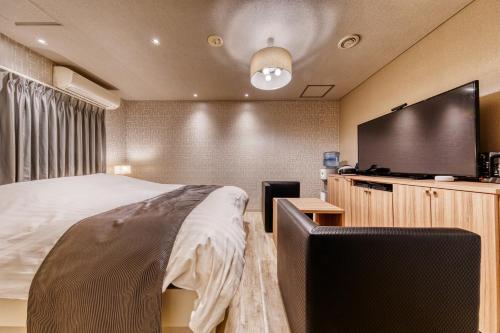 a bedroom with a bed and a flat screen tv at HOTEL LUNA MODERN Sakuranomiya (Adult Only) in Osaka
