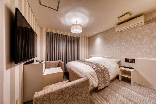 a hotel room with a bed and a chair at HOTEL LUNA MODERN Sakuranomiya (Adult Only) in Osaka