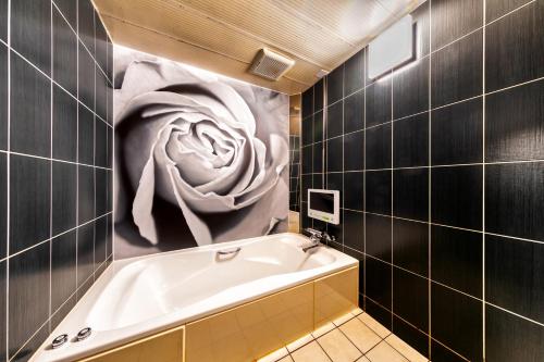 a bathroom with a large painting of a flower on the wall at HOTEL LUNA MODERN Sakuranomiya (Adult Only) in Osaka