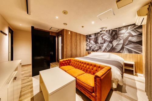 a bedroom with a bed and a couch at HOTEL LUNA MODERN Sakuranomiya (Adult Only) in Osaka