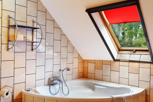 a bathroom with a bath tub and a window at Gościniec pod Żaglami in Skoki Duże