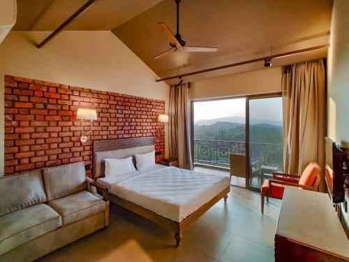1 dormitorio con cama, sofá y ventana en Advait Resort Kshetra Mahabaleshwar en Mahabaleshwar