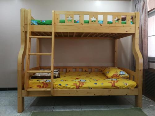 a bunk bed with a wooden bunk bed frame at D-Toys Homestay in Khon Kaen