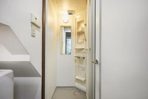 ein kleines Bad mit einer weißen Tür und einem Waschbecken in der Unterkunft Ka's house in Tokio