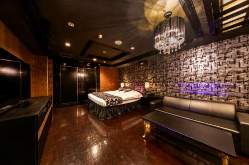 a bedroom with a bed and a couch in a room at HOTEL Artia Ogaki (Adult Only) in Ogaki