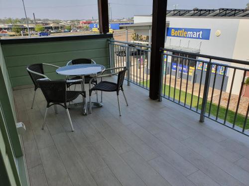 a balcony with a table and chairs and a baseball field at Porter's Plainland Hotel in Plainland