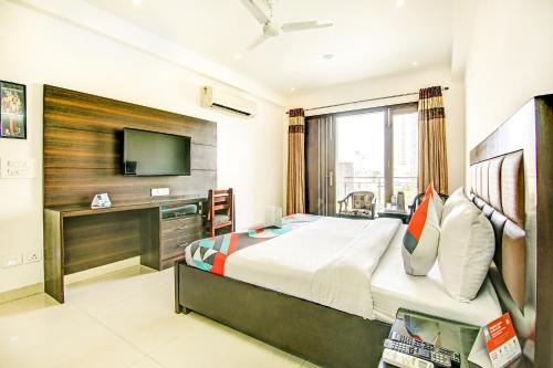 a hotel room with a bed and a television at FabExpress Hemkunt Residency Noida in Noida