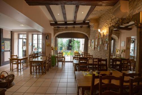 a restaurant with wooden tables and chairs in a room at H&ocirc;tel R&eacute;publique in Dijon