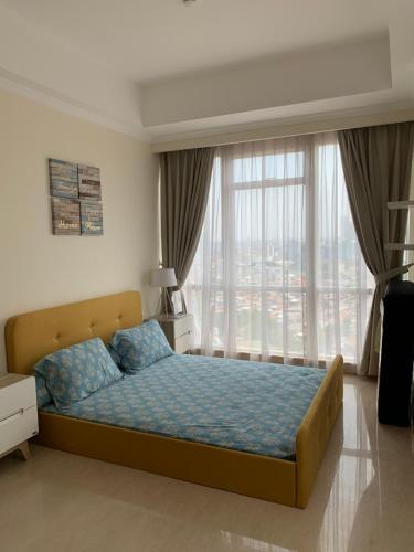 une chambre avec un lit et une grande fenêtre dans l'établissement Menteng Park 19th, à Jakarta