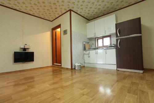 an empty room with a kitchen with a refrigerator at Chamjoeun Pension in Jecheon