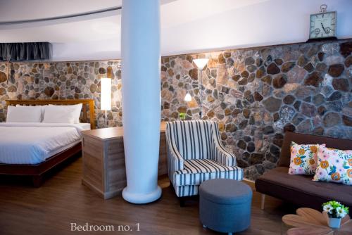 a hotel room with a bed and a couch at Koh Mak Cococape Resort in Ko Mak