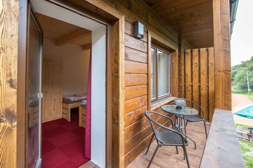a wooden cabin with a table and chairs on a porch at Penzion HORA in Ratiboř