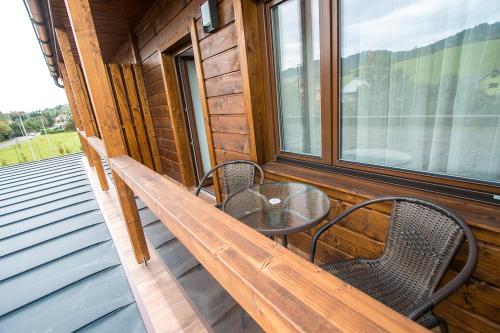 a porch with a table and two chairs on it at Penzion HORA in Ratiboř