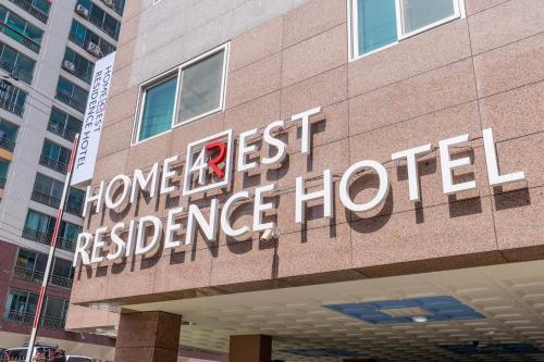 a hotel sign on the side of a building at Home Fourest Residence Hotel Okpo in Geoje 