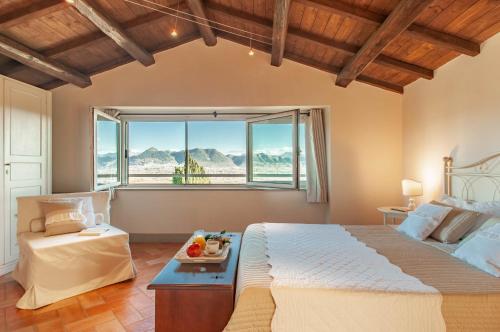- une chambre avec un grand lit et une grande fenêtre dans l'établissement Antica Residenza Montereano, à Gubbio