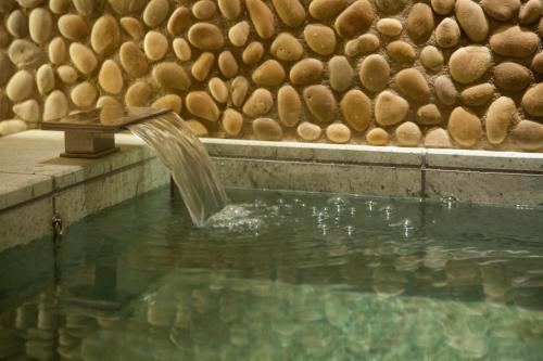 a water fountain in a pool next to a wall at The Hotel Seiryu Kyoto Kiyomizu - a member of the Leading Hotels of the World- in Kyoto