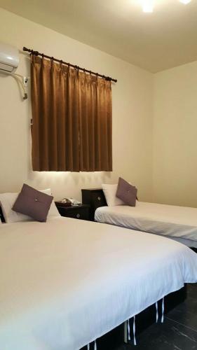 a room with two beds and a window at Jiou Wu Siao Jhu in Nangan