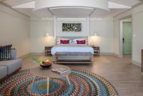 a bedroom with a bed and a couch and a table at Anantara Bazaruto Island Resort in Bazaruto