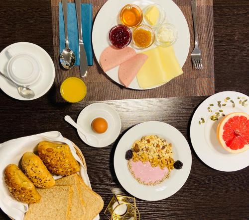 a table with plates of breakfast foods and drinks at Hotel Arena in Cologne