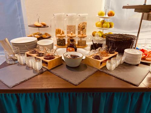 une table avec des assiettes et des tasses de nourriture et des desserts dans l'établissement Hotel Arena, à Cologne