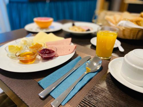 a table with plates of food and utensils and drinks at Hotel Arena in Cologne