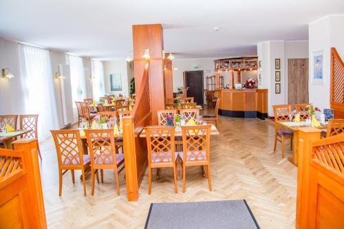 a dining room with wooden tables and chairs at Waldhotel Friedrichroda in Friedrichroda