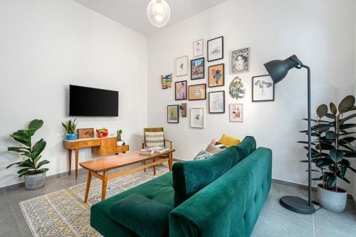a living room with a green couch and a table at Urban Luxe Apartment - Central TLV by Sea N' Rent in Tel Aviv