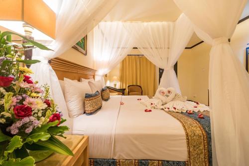 Postel nebo postele na pokoji v ubytování Legian Paradiso Hotel