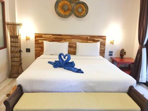 a bed with a blue ribbon sitting on top of it at Wind Beach Resort in Koh Tao